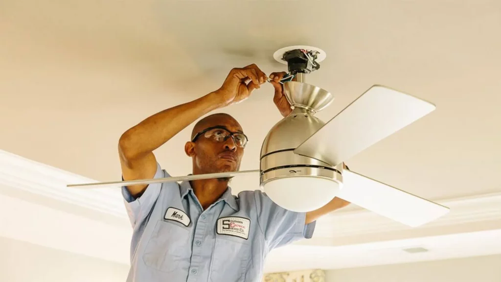 Homem instalando um ventilador de teto