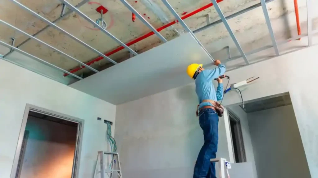 Homem instalando Drywall no teto