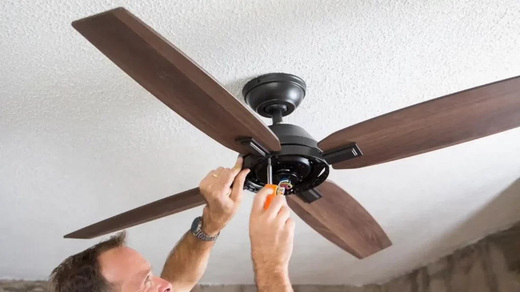 Homem instalando ventilador de teto em teto de gesso