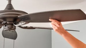 Pessoa verificando a pá do ventilador de teto